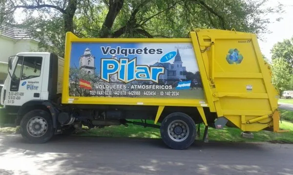 Camión de Volquetes Pilar transportando contenedor de escombros en obra de construcción